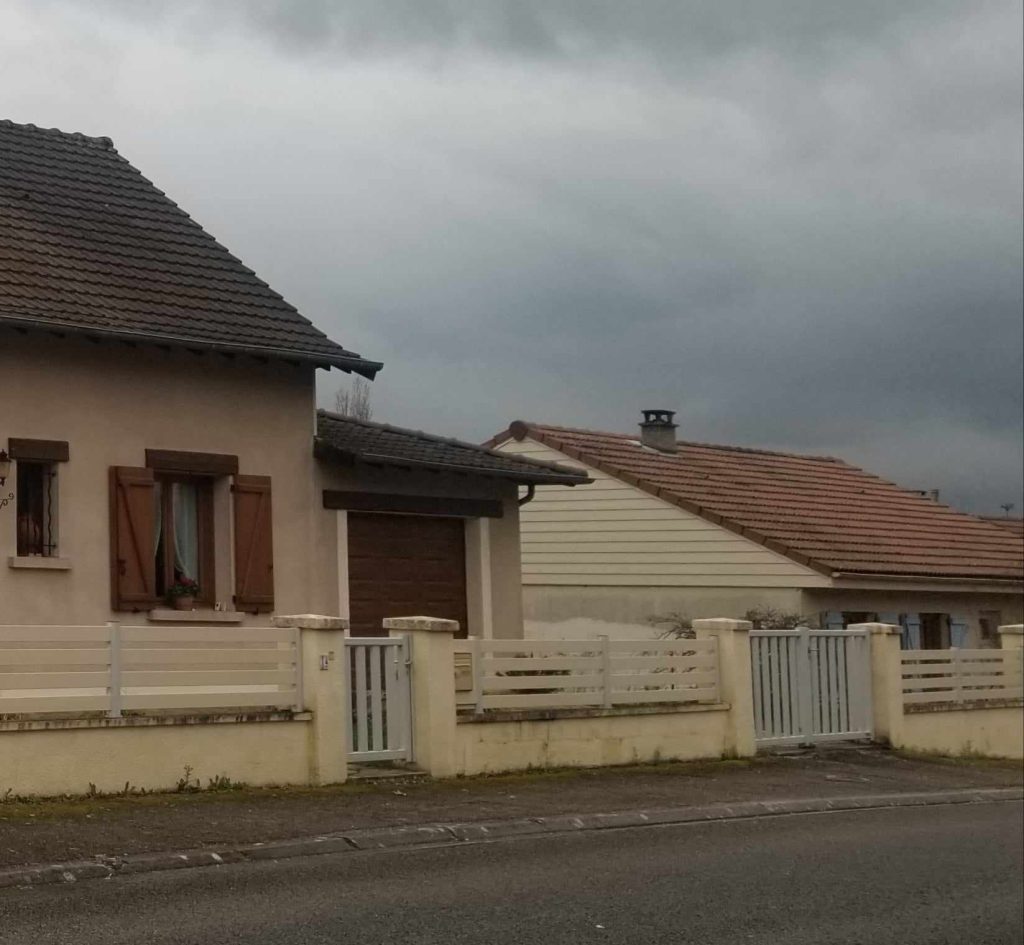 Maison avec nuages sombres